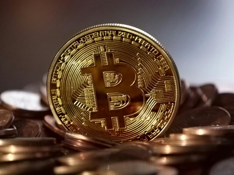 Close-up of a digital cryptocurrency Bitcoin coin placed on a pile of coins.